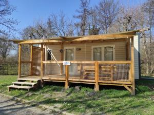 mały drewniany dom z gankiem i gankiem w obiekcie Family's Camping Le Savoy w mieście Challes-les-Eaux