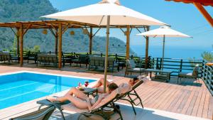 two women laying in chairs next to a swimming pool at Tree Houses Hotel in Fethiye