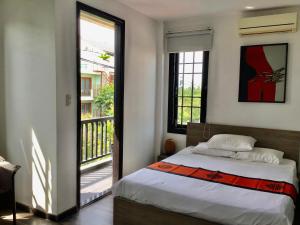 a bedroom with a bed and a balcony at Ki Nô Homestay in Hoi An