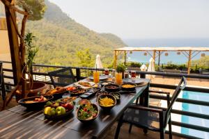 a table with bowls of food on a balcony at Tree Houses Hotel in Fethiye