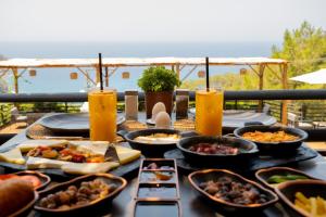 a table with many different dishes of food on it at Tree Houses Hotel in Fethiye