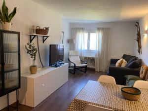 uma sala de estar com um sofá e uma televisão em Apartament Orbis La molina em La Molina