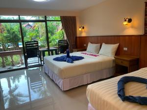 a hotel room with two beds and a window at Laguna Beach Club Resort in Ko Lanta