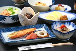 einen Tisch mit Schalen verschiedener Arten von Lebensmitteln in der Unterkunft Tougoukan in Yurihama