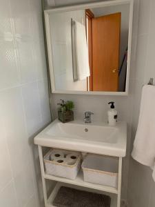 y baño con lavabo blanco y espejo. en La Casita de Mari en Estepona
