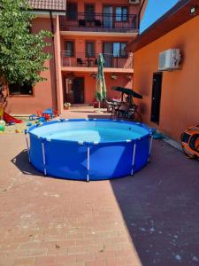 a large blue hot tub in a courtyard next to a building at Vila Dan in Costinesti