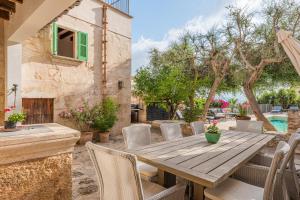 une table et des chaises en bois sur une terrasse avec une piscine dans l'établissement Numero Uno, à Búger