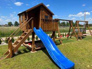 a playground with a slide and a play house at Beztroski Zakątek in Nowe Guty