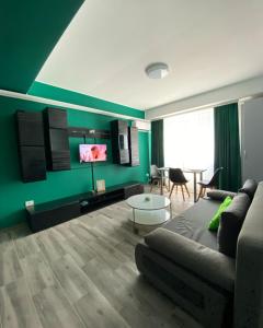 uma sala de estar com um sofá e uma televisão em Green Studio em Mamaia Nord – Năvodari