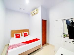 a bedroom with a bed and a flat screen tv at OYO 91283 Sg Premium Guest House in Medan