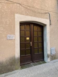 a wooden door in the side of a building at Studio cosy dans le centre-ville historique in LʼIsle-sur-la-Sorgue