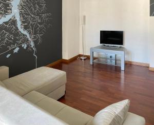 a living room with a couch and a tv at Large well-equipped appartement near Como lake in Lecco
