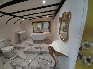 ein Badezimmer mit einem Waschbecken, einer Badewanne und einem WC in der Unterkunft Stone Court House in Maidstone