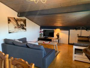 ein Wohnzimmer mit einem blauen Sofa und einem Tisch in der Unterkunft Appartement Bigarena in Hendaye
