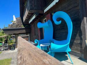 una sedia blu seduta sopra un tavolo di legno di Gemütliches Chalet an bester Lage a Jona