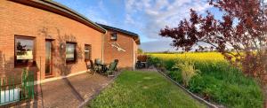 a brick house with a patio and a field of flowers at "Ferienhof Alte Mühle" W 4 in Bannesdorf