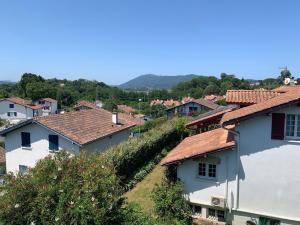 eine Gruppe von Häusern mit roten Dächern in einer Stadt in der Unterkunft Appartement Bigarena in Hendaye
