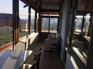 a screened in porch with a couch and chairs and windows at müstakil köy evi in Trabzon