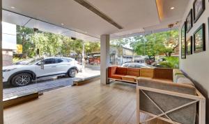 a living room with a couch and a car outside at Upar Hotels Cinecity Kodambakkam RAGHAVENDRA MANDAPAM in Chennai