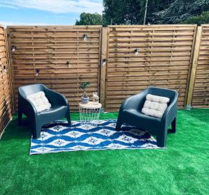 dos sillas sentadas en el césped frente a una valla en Louisiana - Chambre privative, en Calais