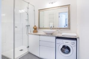 a bathroom with a washing machine and a sink at Krakow Central Apartments in Kraków