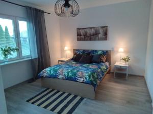 a bedroom with a bed and two lamps and a window at domek u Kazi in Sadowne