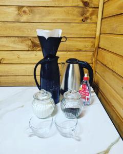 un vase noir et trois bols de verre sur une table dans l'établissement Casa Teka Urubici, à Urubici