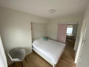 1 dormitorio pequeño con 1 cama y 1 silla en ‘t Hoekje 49, en Biggekerke