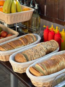 a table topped with baskets of bread and fruit at Hotel Sweet in Mamaia Sat/Năvodari