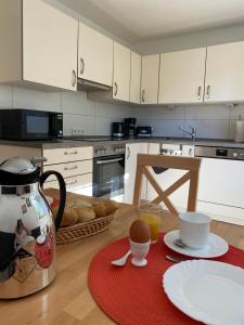 a kitchen with white cabinets and a table with a coffee maker at Ferienwohnung Bergstraße in Wilhelmsfeld