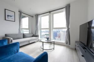 uma sala de estar com um sofá e uma mesa em Luxury penthouse with stunning views near Canary Wharf em Londres