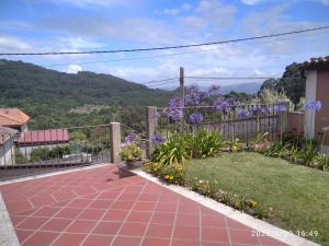 a garden with purple flowers and a fence at casa rústica Cabo Home in Cangas de Morrazo