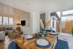 a kitchen and living room with a wooden table at Coastal Cottage in North Wales With Hot Tub in Abergele
