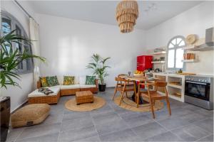 Divino Suites في فيرا: مطبخ وغرفة معيشة مع طاولة وكراسي