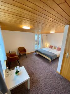 a bedroom with a bed and a table and a chair at Simple Room 1 in Oberbüren