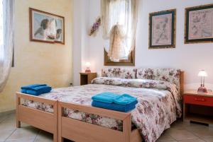 ein Schlafzimmer mit einem Bett mit blauen Handtüchern darauf in der Unterkunft AFFITTACAMERE L'ARCOBALENO in Porto Torres