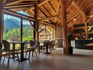 une salle à manger avec une table, des chaises et une grande fenêtre dans l'établissement Le PasSionNant, à Morzine