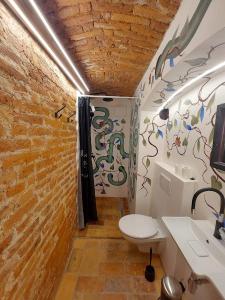 a bathroom with a toilet and a wall with graffiti at Villa Coola in Ljubljana