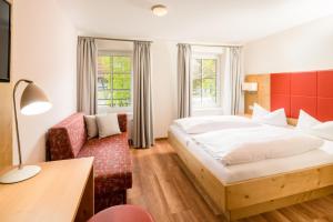 ein Hotelzimmer mit einem Bett und einem Sofa in der Unterkunft Landhotel Alte Mühle in Ostrach