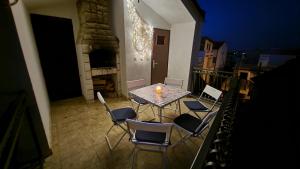 a table and chairs on a balcony with a fireplace at Perlica in Vodice