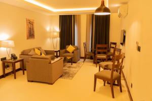 ein Wohnzimmer mit einem Sofa, Stühlen und einem Tisch in der Unterkunft Tulip Inn Majan Hotel in Salalah
