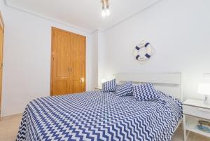 ラ・マタにあるApartment Versueñoのベッドルーム1室(青と白のベッド1台、木製のドア付)