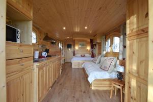 a large room with a kitchen and a bed in a tiny house at La Maison Rouge Ladoix - Proche Beaune in Ladoix Serrigny