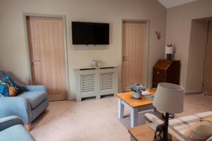 a living room with a blue couch and a tv at Acorn Apartment in York