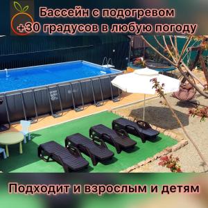 um grupo de cadeiras sentadas ao lado de uma piscina em Guest House Apelsin em Yeysk