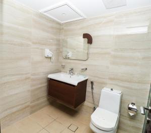 a bathroom with a sink and a toilet and a mirror at Maskan Almadinah in Dammam