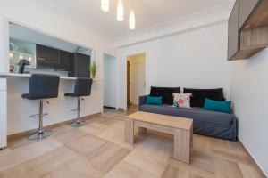 Una sala de estar con un sofá azul y una mesa. en Cosy Studio Soleia, 50m from sea side, en Menton 15 fotos más