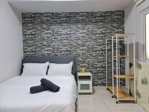 a bedroom with a bed and a brick wall at Maritime Luxury Duplex 2Bedrooms 6-10pax in Jelutong
