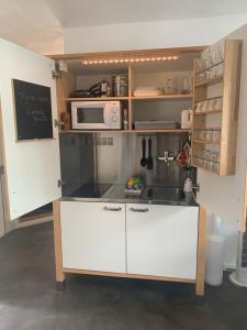 een keuken met een wastafel en een magnetron bij Luxe appartement met sauna in Drachten
