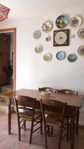mesa de comedor con sillas y platos en la pared en La Casa del Lupo, en Collimento